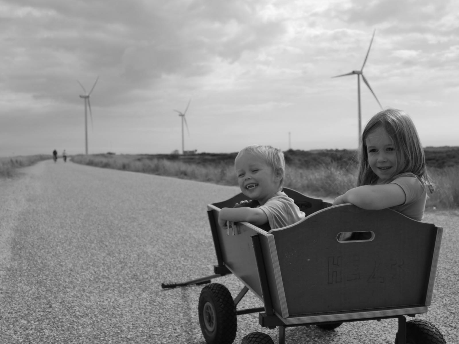 twee kindjes in een kar met windmolens op de achtergrond